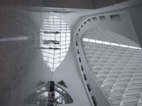 the roof of a building with multiple windows is white in color and has metal rods