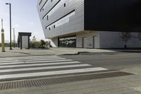 a white and black building with a crosswalk in front of it on a sunny day