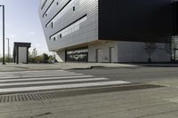 a white and black building with a crosswalk in front of it on a sunny day