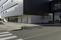 a white and black building with a crosswalk in front of it on a sunny day