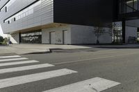 a white and black building with a crosswalk in front of it on a sunny day