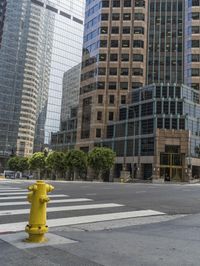 this is an empty city street with a yellow fire hydrant in the foreground