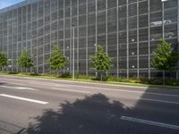 a large glass office building on an empty street in the daytime with no one on