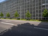 a large glass office building on an empty street in the daytime with no one on