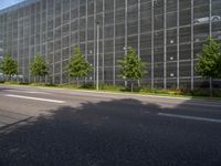 a large glass office building on an empty street in the daytime with no one on