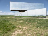 a mirror that is on top of grass and dirt in the ground near a field