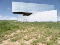 a mirror that is on top of grass and dirt in the ground near a field