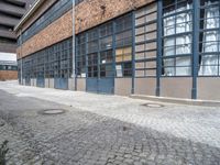 there is an open window on this brick building with concrete curb in front of it