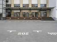 an empty building with signs on the street and people on bikes in traffic passing by