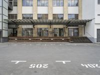 an empty building with signs on the street and people on bikes in traffic passing by