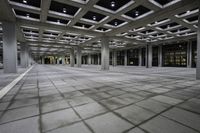 there is a courtyard inside a building with columns and ceiling lights on the floor and a large concrete structure