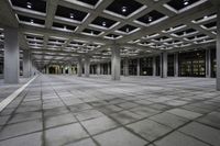 there is a courtyard inside a building with columns and ceiling lights on the floor and a large concrete structure