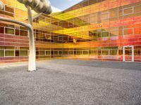 there is a building with a large glass front and yellow back and windows with multicolored sky