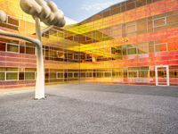 there is a building with a large glass front and yellow back and windows with multicolored sky