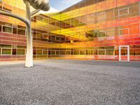 there is a building with a large glass front and yellow back and windows with multicolored sky