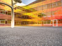 there is a building with a large glass front and yellow back and windows with multicolored sky