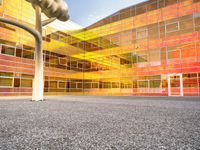 there is a building with a large glass front and yellow back and windows with multicolored sky