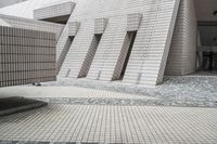 a small courtyard with bricks around the corner and a bench under it to sit on