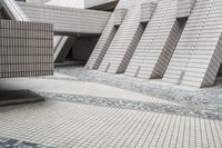 a small courtyard with bricks around the corner and a bench under it to sit on