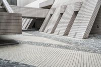 a small courtyard with bricks around the corner and a bench under it to sit on