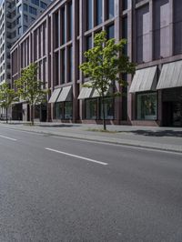 a empty road with people walking by some buildings and cars on it's sides