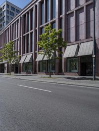 a empty road with people walking by some buildings and cars on it's sides