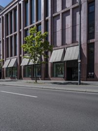 a empty road with people walking by some buildings and cars on it's sides