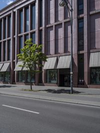 a empty road with people walking by some buildings and cars on it's sides