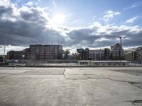 a parking lot with a road and a large building in the back ground and a large construction crane in the background