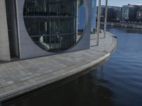 an open area with a water way that goes around it, and a circular building near by