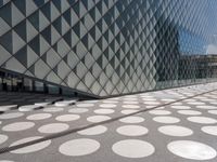 a large polka dot floor near a building next to a glass door on a walkway