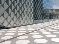 a large polka dot floor near a building next to a glass door on a walkway