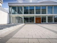 this is an image of a building entrance with an empty street below it and a man walking across a path