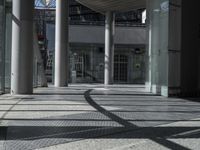 a sidewalk with several columns and an outside bench that has a curved design on it