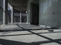 a sidewalk with several columns and an outside bench that has a curved design on it