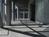 a sidewalk with several columns and an outside bench that has a curved design on it