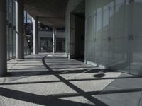 a sidewalk with several columns and an outside bench that has a curved design on it