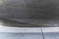 a person walking through a courtyard with an umbrella on the floor by a wall and curved roof