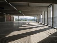 a person walking around an empty parking lot by some large windows that have some blinds