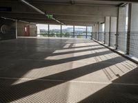 a person walking around an empty parking lot by some large windows that have some blinds