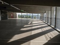 a person walking around an empty parking lot by some large windows that have some blinds