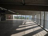 a person walking around an empty parking lot by some large windows that have some blinds