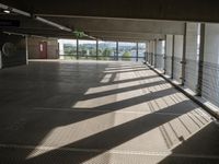 a person walking around an empty parking lot by some large windows that have some blinds