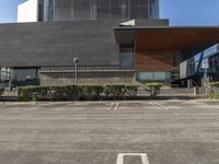 a building with two parking spaces on the lot in front of it, and an entrance sign, next to a sign saying international education