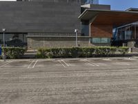 a building with two parking spaces on the lot in front of it, and an entrance sign, next to a sign saying international education