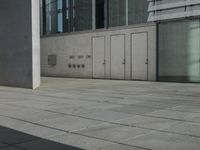 a skateboard parked in front of an office building with doors open on the side walk