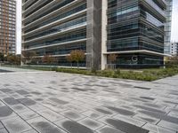 several buildings near each other with gray granite pavers on the ground in front of them