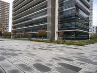 several buildings near each other with gray granite pavers on the ground in front of them