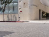 a fire hydrant on the corner of a street in front of the glass building