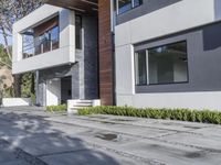 the exterior and landscape of a modern house in los angeles, california with stone and wood